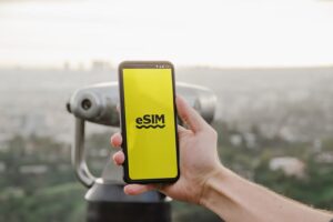 A person holding a cell phone with an eSIM logo