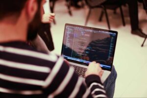 man coding on his laptop computer