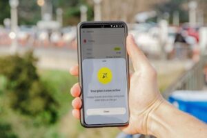 a hand holding a smartphone that displays an eSIM plan activation 