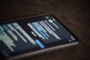 A smartphone lying flat on a surface showing the Telegram "BotFather" chat interface