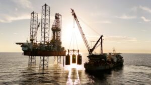 an oil rig being serviced by a supply ship